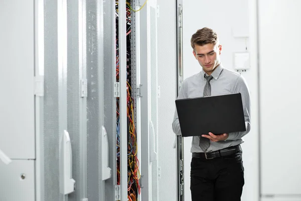 男性的服务器工程师工作笔记本 在大型数据中心 — 图库照片