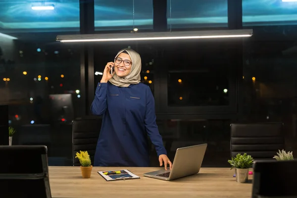 Pretty business hijab woman working alone in dark office