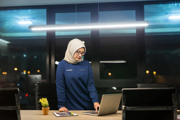 Pretty business woman working alone in dark office