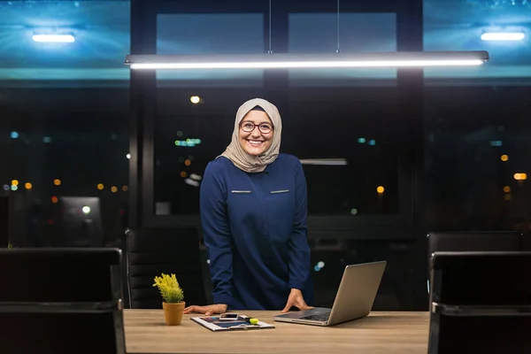 Pretty business hijab woman working alone in dark office