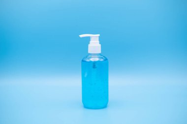 Dezenfektan jel pompası. Pompa şişesinde mikropları, bakterileri ve virüsü öldürmek için dezenfektan var. Mavi arkaplanda izole et