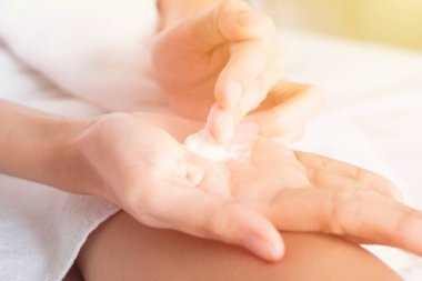 Kadın ellerine nemlendirici krem sürüyor. Güzellik konsepti.