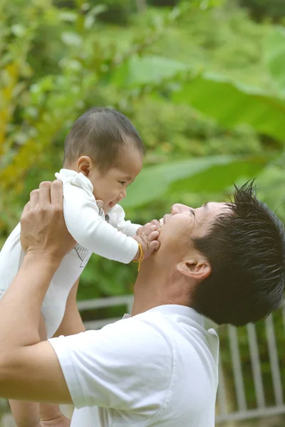 幸せな父の日 楽しい若いお父さんがかわいい息子を抱いて屋外公園で — ストック写真