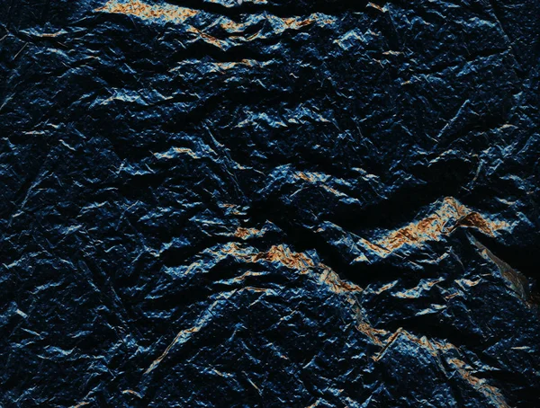 Azul escuro perfurado superfície áspera com rachaduras e inclusões douradas. Pedra irregular. Fundo escuro — Fotografia de Stock