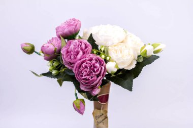 Gri arka planda vazoda beyaz ve mor şakayıklar