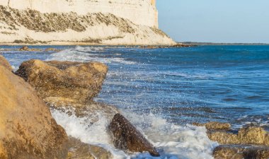  Kıbrıs kıyı şeridinin deniz kenarındaki kayalara çarpan dalgalarla manzarası, doğal ışık altında dinamik sıçramalar ve deniz spreyi yaratarak Akdeniz kıyısının saf güzelliğini gözler önüne seriyor.