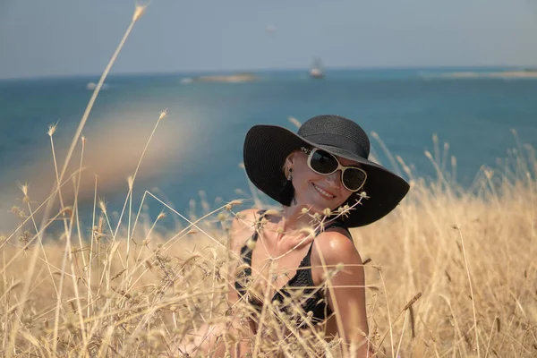 La signorina si siede in un piano a costa di oceano o il mare e gode di un declino — Foto Stock