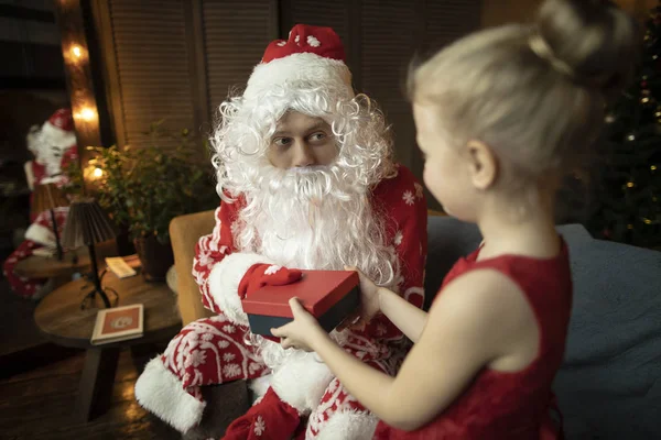 Jultomten ger en gåva till ett barn, men han gillar honom så mycket att han inte vill ge bort det — Stockfoto
