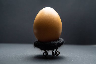 Siyah bir masanın üzerinde bir yumurta duruyor. Paskalya yumurtası arka planı. Çok güzel yumurta. yastık üzerinde en iyi