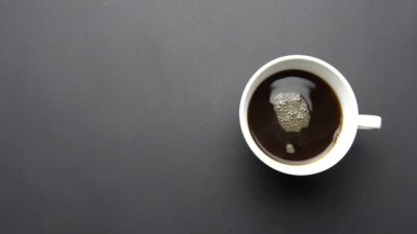 Tahta masada bir fincan kahve. Ahşap masa üzerinde bir fincan kahve karıştırma el, üst görünüm