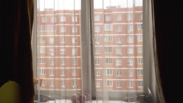 Öppet fönster, gardiner tunna, med utsikt över huset av röda tegelstenar — Stockvideo