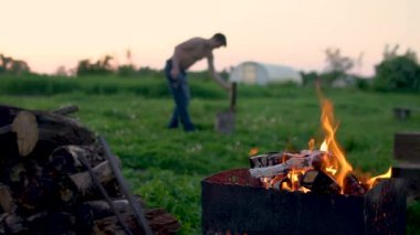 Bir oduncunun arka planında mangal kömürü için ızgara ateş yakın çekim yaz doğa