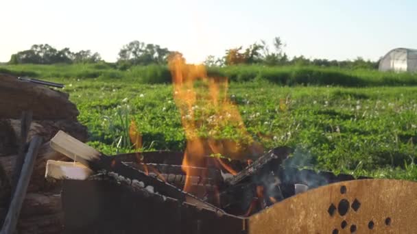 Horno de barbacoa a la parrilla para kebabs llama brillante hoguera en la calle Caliente verano al aire libre en el pueblo — Vídeos de Stock