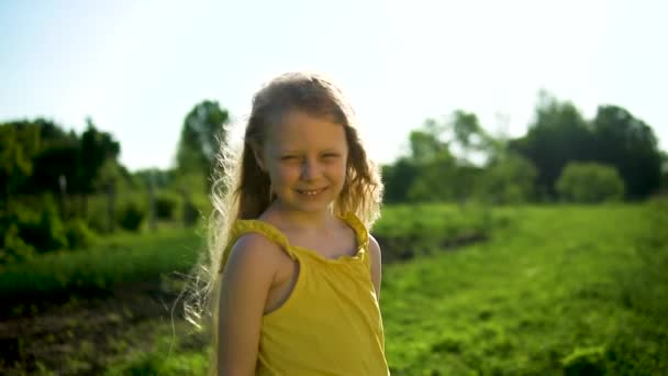 Wesoła młoda dziewczyna o miłym wyglądzie stoi uśmiechnięta, aby cieszyć się koncepcją na tle błękitnego nieba i zielonej trawy na wakacjach. Trawa zielona — Wideo stockowe