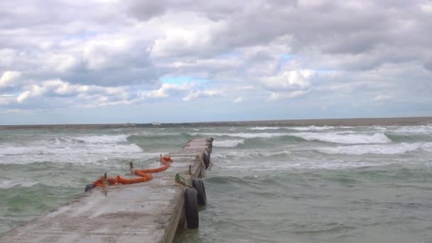 Molo z falą na szarym tle morza z molo, ścieżka do morza — Wideo stockowe