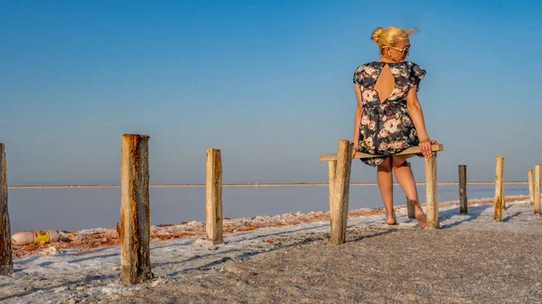 Slenone Lake si siede le ragazze indietro in un abito scuro e guarda di lato, un bel cielo blu chiaro — Foto Stock