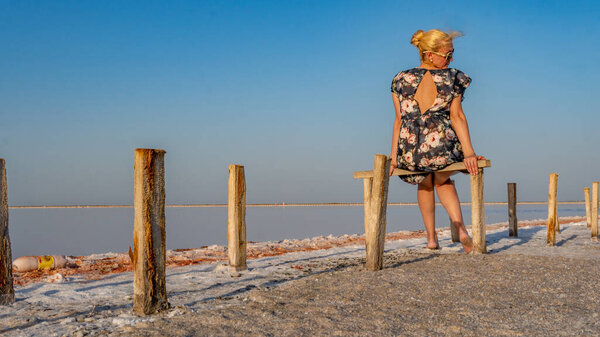 Slenone Lake sits the girls back in a dark dress and looks to the side, a beautiful clear blue sky