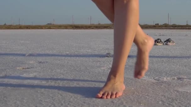 一个女孩赤着脚走在雪地里，白人的样子，走在冰上 — 图库视频影像