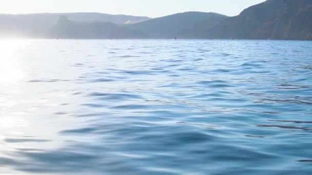 Море лодок, вид с воды на скалы, во второй половине дня в солнечную погоду, с бликами от воды, замедлился — стоковое видео