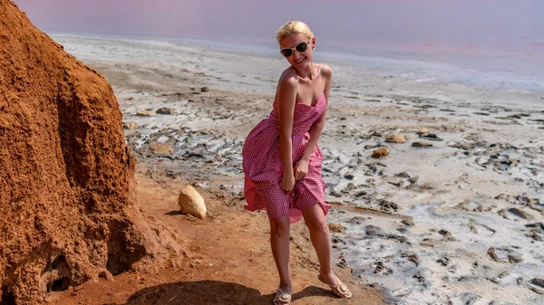 Una ragazza vicino a una roccia, appoggiata a lei, nel pomeriggio d'estate, sullo sfondo di un cielo viola. Bello stile retrò caucasico — Foto Stock