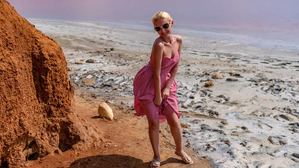 Uma menina perto de uma rocha, apoiando-se nela, à tarde no verão, contra o fundo de um céu roxo. Belo estilo retro caucasiano — Fotografia de Stock