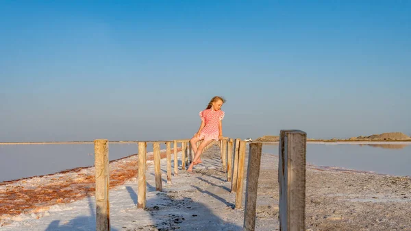 Gioioso in un bellissimo vestito con un sorriso meraviglioso sullo sfondo di un lago salato nel caldo sole — Foto Stock