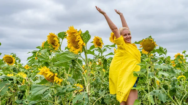 夏の日に青い雲とカメラで笑顔黄色のドレスの美しい若い女性 — ストック写真