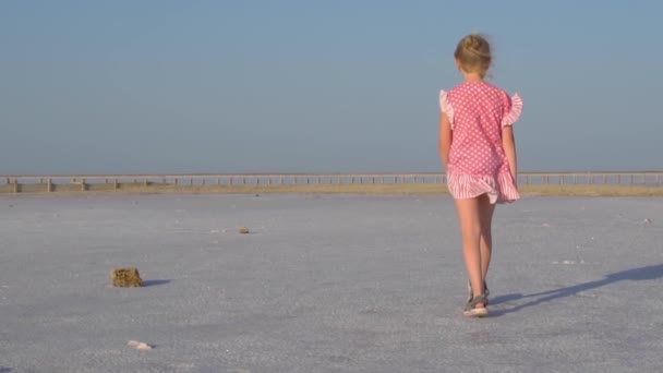 Девушка гуляет по соленому озеру в Крыму, жаркая погода — стоковое видео