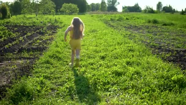 Rolig ung flicka med en bra titt körs på fältet, ett vackert koncept för stadsliv mot bakgrund av grönt gräs och blå himmel i byn. — Stockvideo