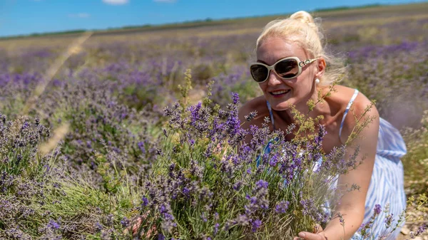 Donna gioiosa su un adulto campo lilla con un look gentile in occhiali da sole gioioso con la pelle bianca sta — Foto Stock