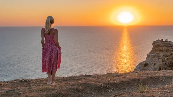 Donna Felice adulto con un bellissimo aspetto guarda il tramonto si erge con la schiena in estate la sera — Foto Stock