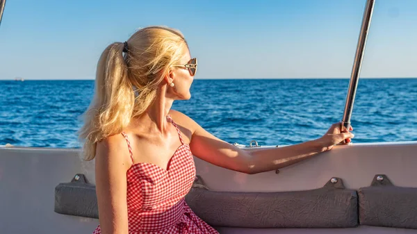 Ragazza sorridente che riposa su una barca, giovane con un bel sorriso all'orizzonte del mare, godersi il concetto in bicchieri monocromatici in estate — Foto Stock