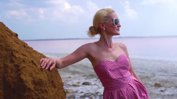 Beautiful woman in a red dress young with a lovely hairstyle blue clouds on a summer day — Stock Video