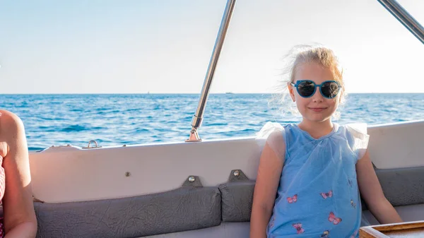 Ragazza allegra appoggiata su uno yacht, giovane con un bel sorriso intorno al mare, il concetto di attività webinar in bicchieri monocromatici in estate — Foto Stock