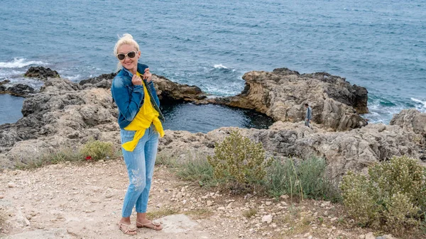 Signora giovani occhiali camaleonti stand felice si erge contro il mare — Foto Stock