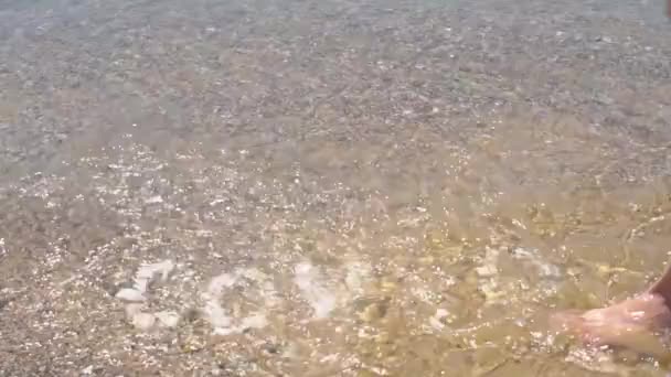 Covid19 надпись смыла вода, волна из океана, надпись сделана из брусчатки, холодная вода смывает надпись с брусчатки в жару на пляже — стоковое видео