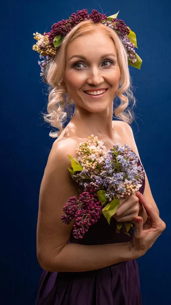 Kvetoucí mladá krásná v šeříku věnec s bílou pletí se zamiluje na modrém pozadí, s — Stock fotografie