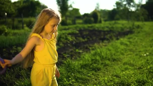 Uma jovem com uma aparência carismática dança com uma lata de rega, o conceito de bem-estar é contra o fundo do céu azul e grama verde no campo. — Vídeo de Stock