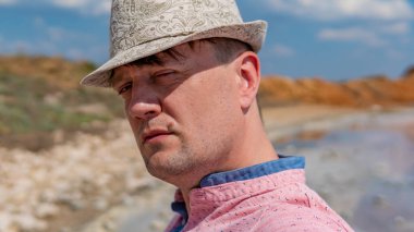 Şapka takan ciddi bir portre. Beyaz gün ışığı mavi gözler.