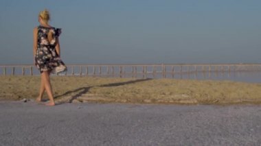 Bir kız tuzlu gölde karda yürür, çıplak ayakla yürür.