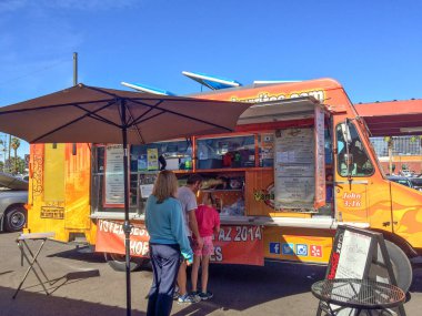 PHOENIX, AZ - FEBRUARY 5, 2016: A family of three ordering lunch from Jamburritos Express Food Truck at designated outdoor spot in downtown of Phoenix, AZ clipart