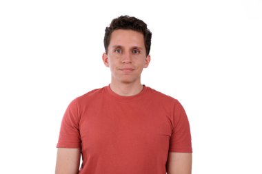 Genç adam, sakin ve sakin, kırmızı tişört giyiyor, beyaz arka planda izole edilmiş.