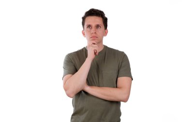 Düşünceli bir genç adam, elleri çenesinde, analiz ediyor, beyaz arka planda yeşil bir tişört giyiyor..