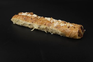 Hamur köftelerini kapayın. İçine susam tohumu serpiştirin. Siyah arka plan konseptine izole edilmiş fırın ürünü ve fast food.