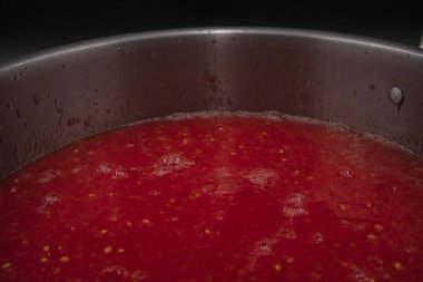 Taze domates püresi ile doldurulmuş metal kap karanlık arka plan konseptine yerleştirilmiş ev yapımı organik sebze hazırlama ve sağlıklı gıda