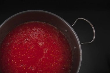 Taze domates püresi ile doldurulmuş metal kap karanlık arka plan konseptine yerleştirilmiş ev yapımı organik sebze hazırlama ve sağlıklı gıda