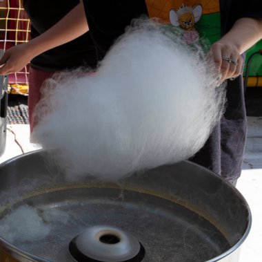 Sokak yemeği standında çubuğa sarılmış pamuk helva. Fuarlarda, karnavallarda ve festivallerde popüler tatlı pofuduk bir tatlı..