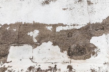 Çatlak alçılı ve soyulmuş boya desenli eski bir duvar. Grunge tasarımı, kentsel bozulma temaları ve eski bina yüzeyleri için ideal arkaplan.