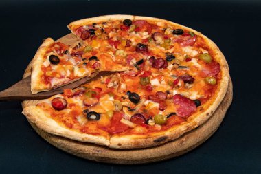 Tahta tahtada servis edilen peynirli, zeytinli, mantarlı, domatesli ve sebzeli nefis ev yapımı pizza menü, kafe ve reklam için yakın plan yiyecek konsepti.