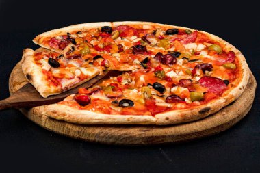 Tahta tahtada servis edilen peynirli, zeytinli, mantarlı, domatesli ve sebzeli nefis ev yapımı pizza menü, kafe ve reklam için yakın plan yiyecek konsepti.